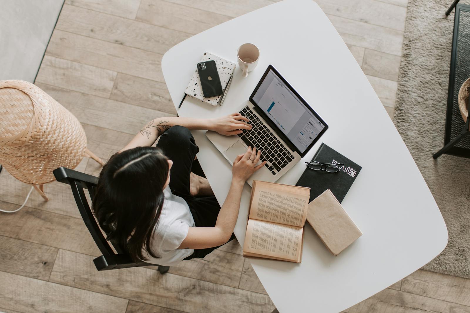 Independent business owner working from a bright desk with a laptop, notebook, and planning materials.